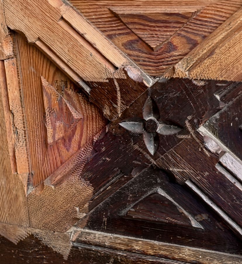 Lackentfernung mit Laser an einer alten Holzhaustür in Lübeck: hellere freigelegte Holzbereiche neben noch dunkel lackierten Flächen der profilierten Türfüllung.